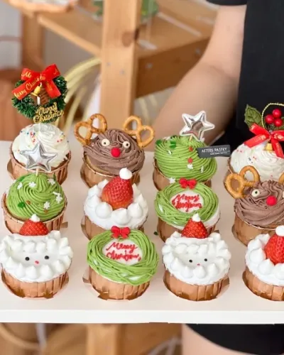 Christmas vanilla sponge cupcake with festive frosting and Santa-themed toppings