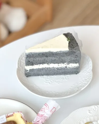 Slice of black sesame and soybean cake with creamy soy filling and dark sponge