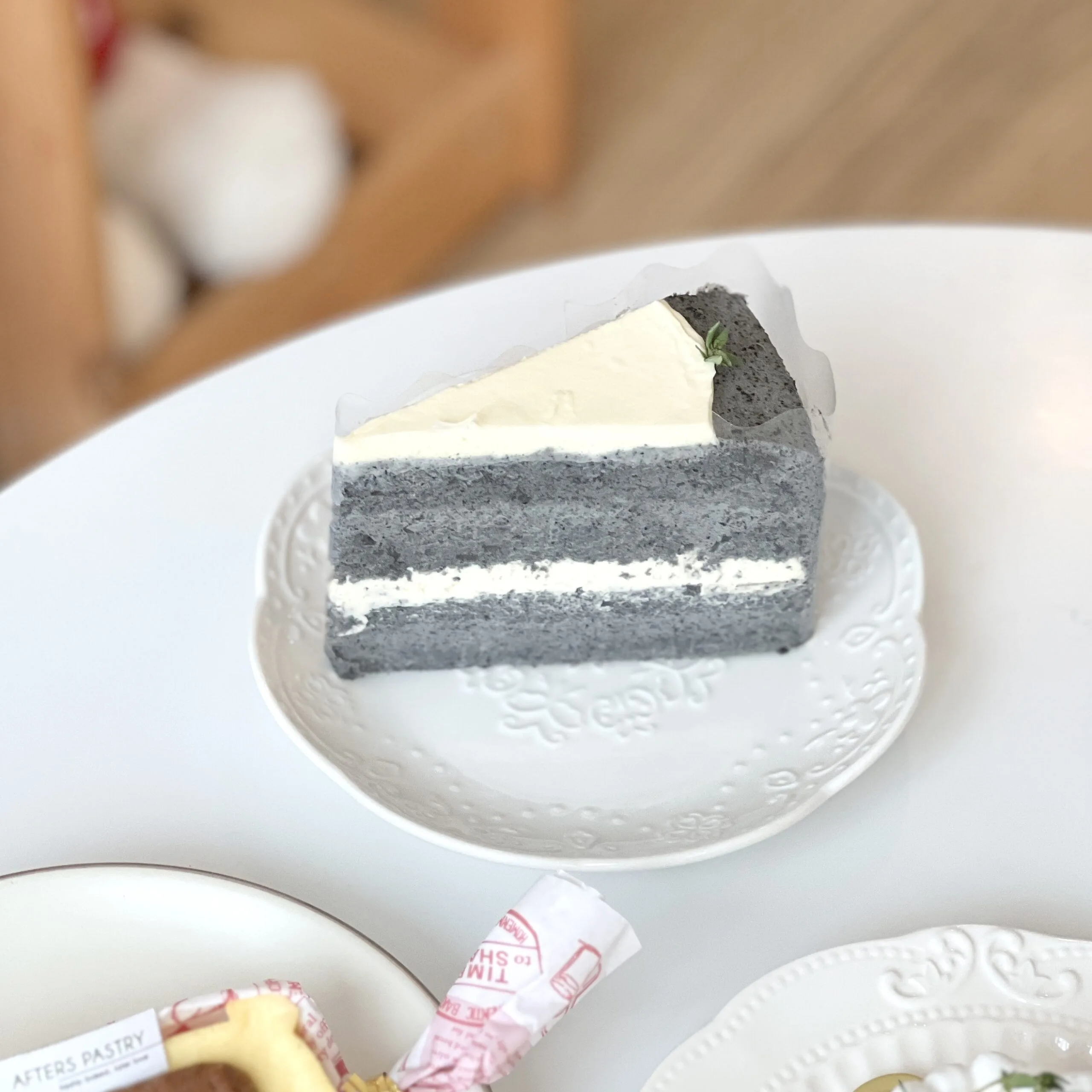 Slice of black sesame and soybean cake with creamy soy filling and dark sponge