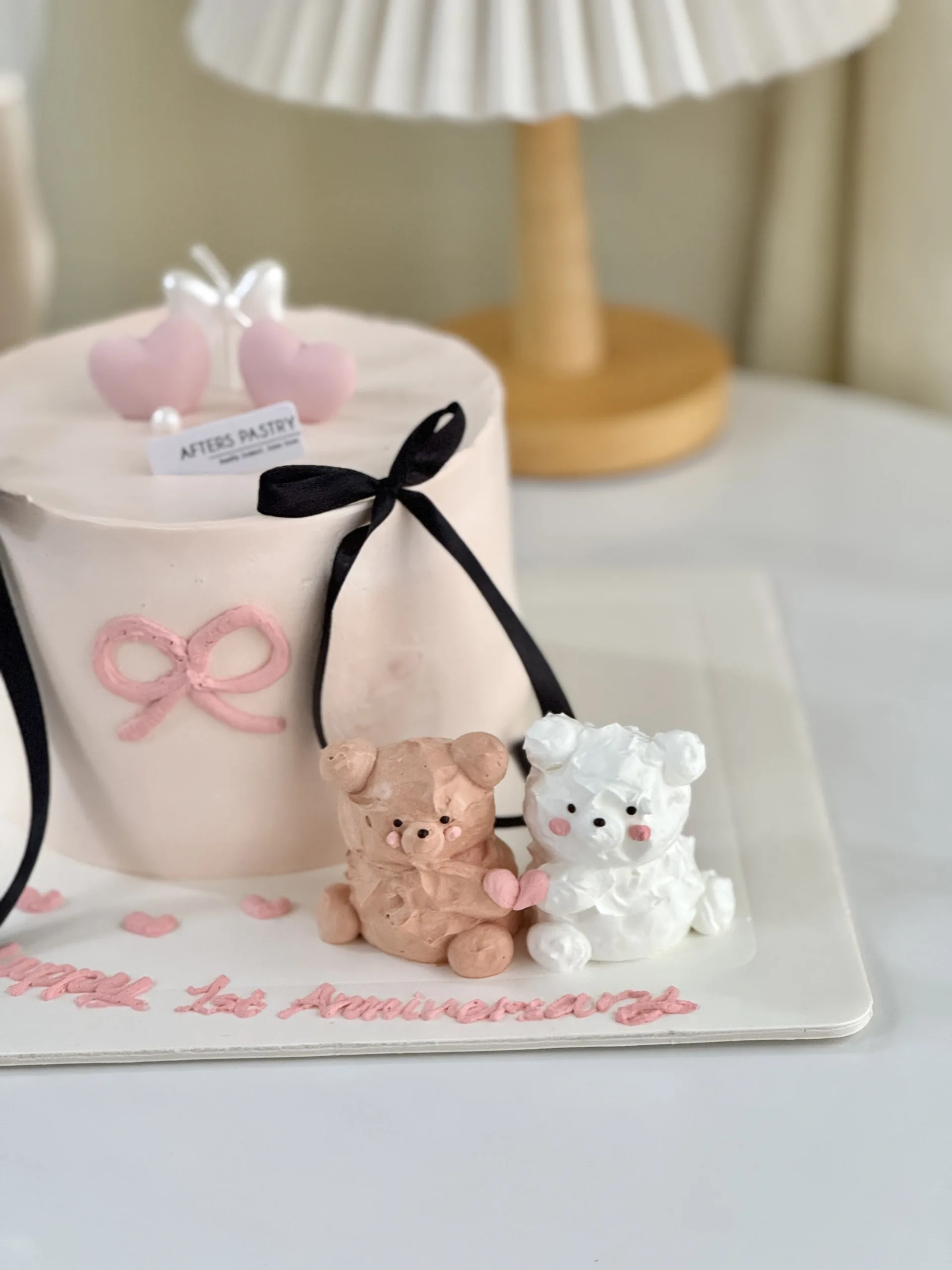 Bear-themed anniversary cake with cute couple topper and pastel decorations