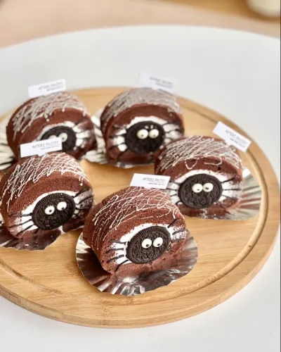 Halloween chocolate Swiss roll cake with festive decor including ghosts and pumpkins