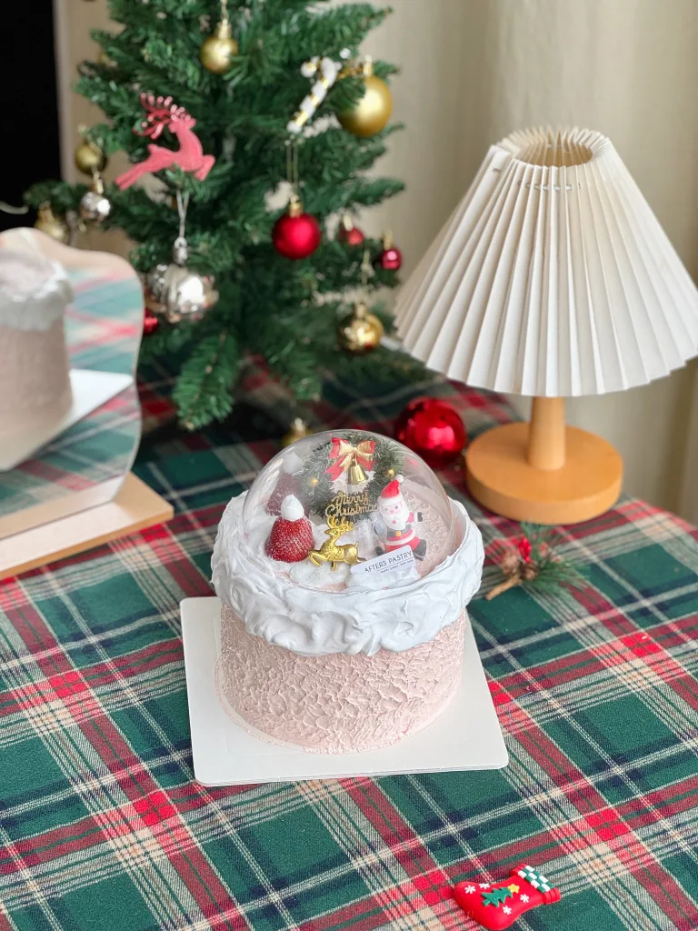 Snow Globe Christmas Cake with festive dome topper and five sponge flavours on a holiday table